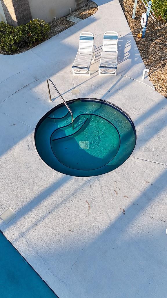 view of swimming pool featuring an in ground hot tub