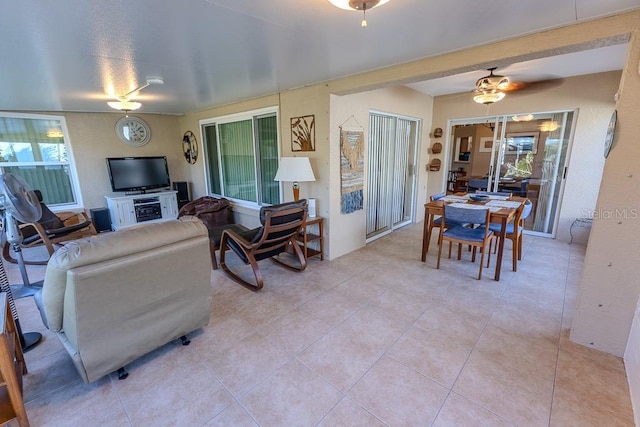 tiled living room featuring a healthy amount of sunlight and ceiling fan