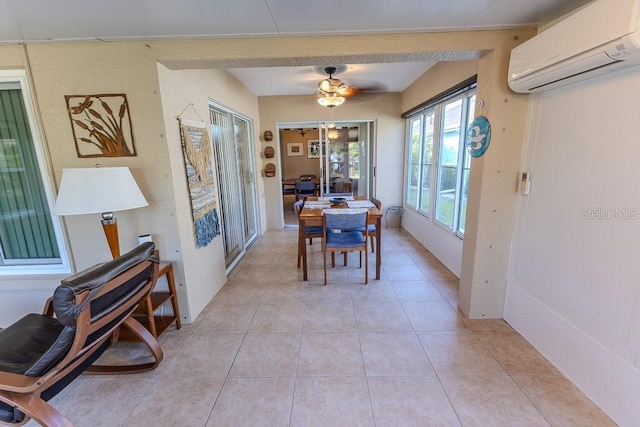 tiled dining area with an AC wall unit and ceiling fan