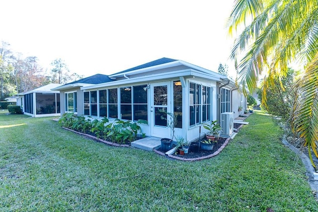 back of property featuring a sunroom and a yard