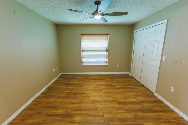 1604 Boswell Ln, New Port Richey, FL 34655 - unfurnished bedroom featuring wood finished floors, a closet, a textured ceiling, and baseboards