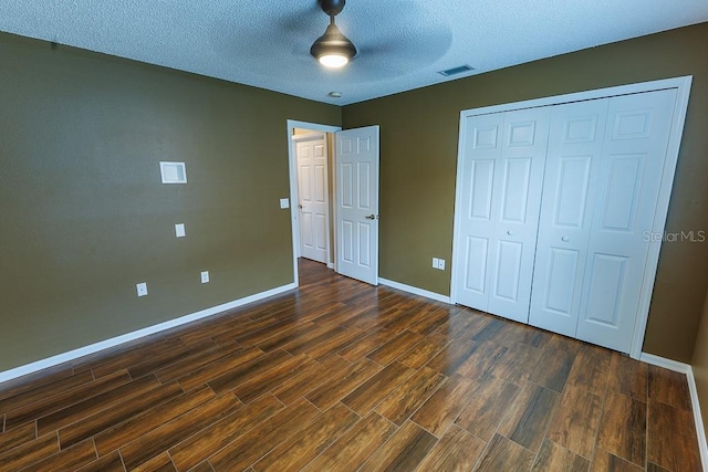 1604 Boswell Ln, New Port Richey, FL 34655 - unfurnished bedroom with dark wood-style floors, baseboards, a closet, and a textured ceiling