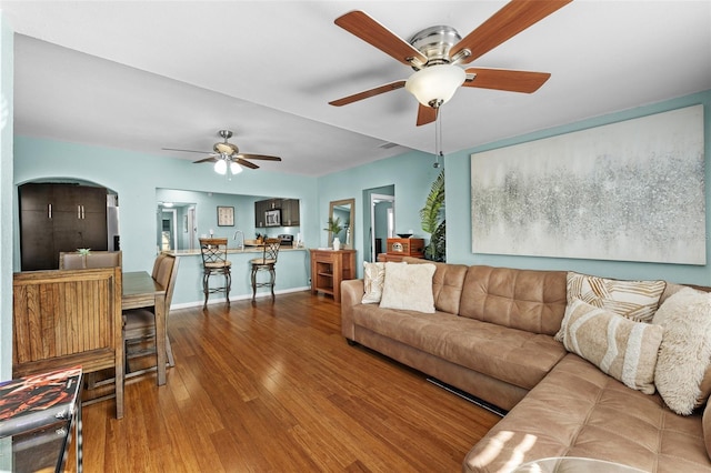 living room with ceiling fan, wood-type flooring, and sink