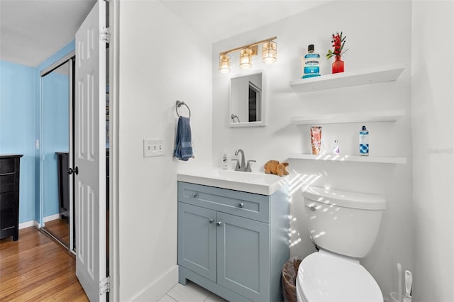 bathroom with toilet, wood-type flooring, and vanity