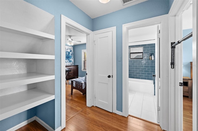 interior space with built in shelves and hardwood / wood-style floors