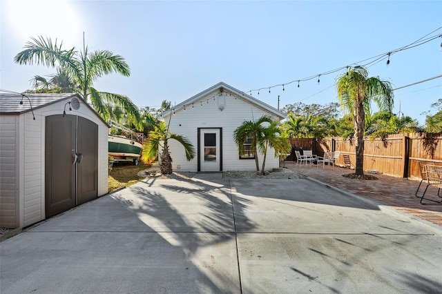 view of front of house with a patio area and a shed