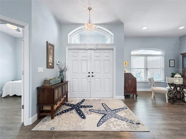 entryway with dark hardwood / wood-style floors and an inviting chandelier