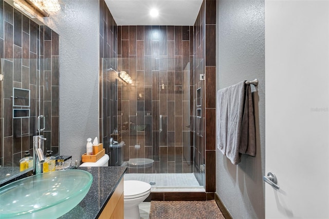 bathroom featuring a shower with door, tile patterned flooring, vanity, and toilet