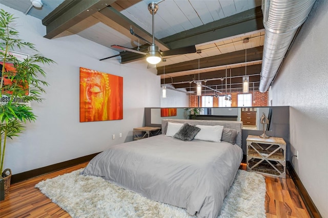 bedroom featuring ceiling fan, beamed ceiling, and wood-type flooring