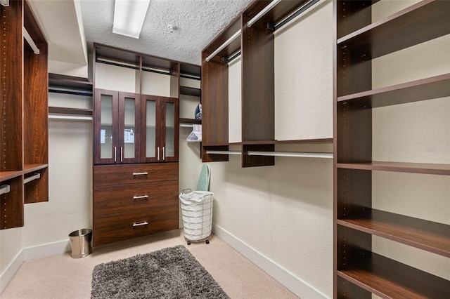 walk in closet featuring light colored carpet