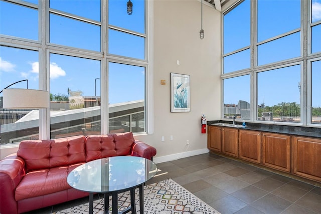 living room featuring sink, a high ceiling, and dark tile patterned flooring