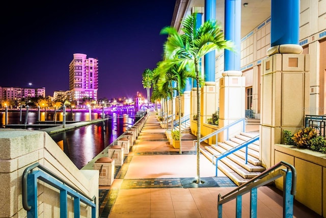 balcony at twilight featuring a water view