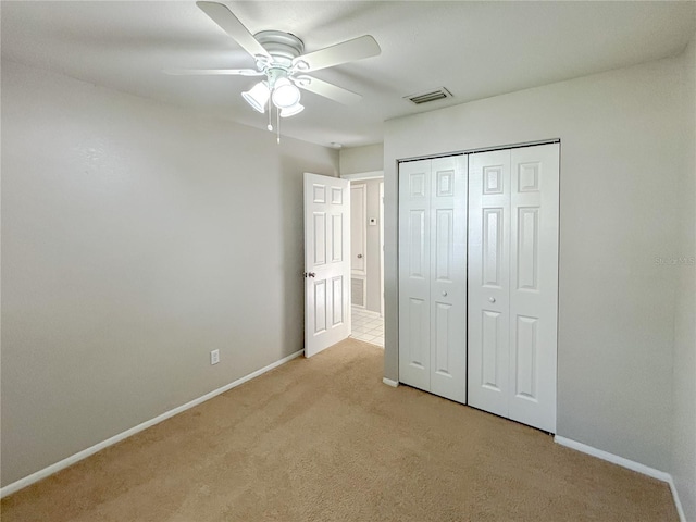 unfurnished bedroom with a closet, ceiling fan, and light colored carpet