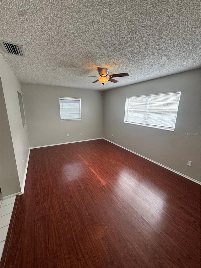 empty room featuring dark wood-type flooring and ceiling fan