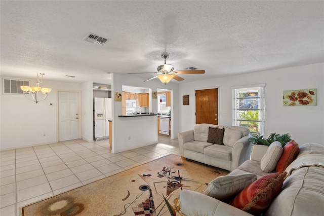 tiled living room featuring ceiling fan with notable chandelier and a textured ceiling