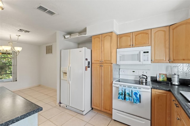 kitchen with light tile patterned flooring, a chandelier, backsplash, and white appliances