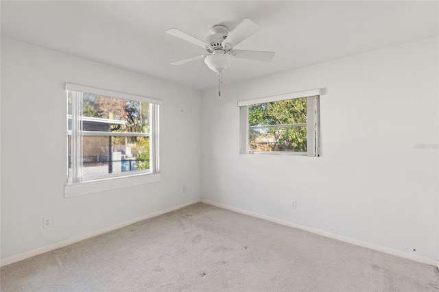 carpeted spare room featuring ceiling fan