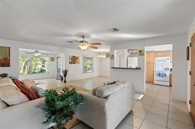 tiled living room with ceiling fan and a textured ceiling