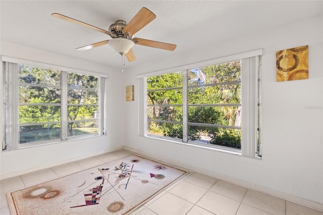 unfurnished sunroom with ceiling fan and a healthy amount of sunlight