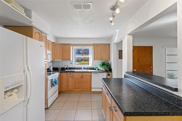 kitchen with light tile patterned flooring, sink, a textured ceiling, light brown cabinets, and white appliances