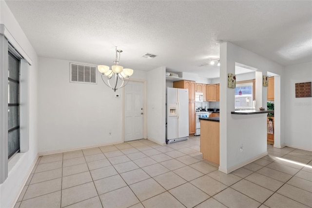 kitchen featuring pendant lighting, white appliances, a textured ceiling, light tile patterned flooring, and a chandelier