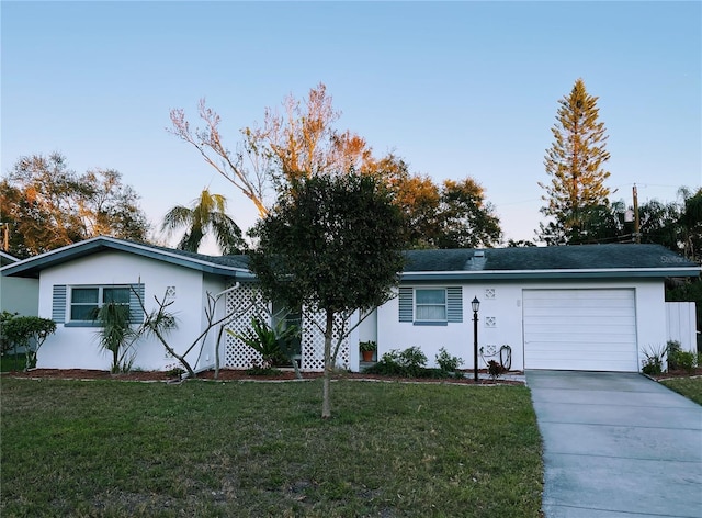 ranch-style house featuring a garage and a front lawn