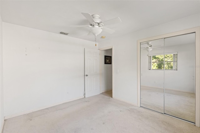 unfurnished bedroom with ceiling fan, light colored carpet, and a closet