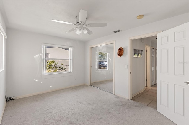 unfurnished bedroom featuring ceiling fan, a closet, and light carpet