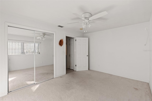 unfurnished bedroom featuring ceiling fan, a closet, and carpet