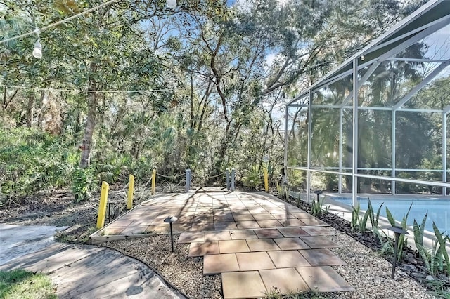 view of patio featuring glass enclosure