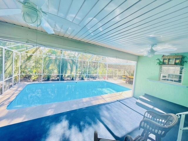 view of pool with a lanai, ceiling fan, and a patio