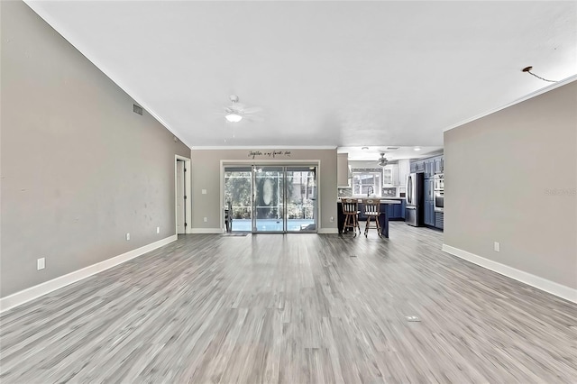 unfurnished living room with ceiling fan, ornamental molding, and light hardwood / wood-style floors