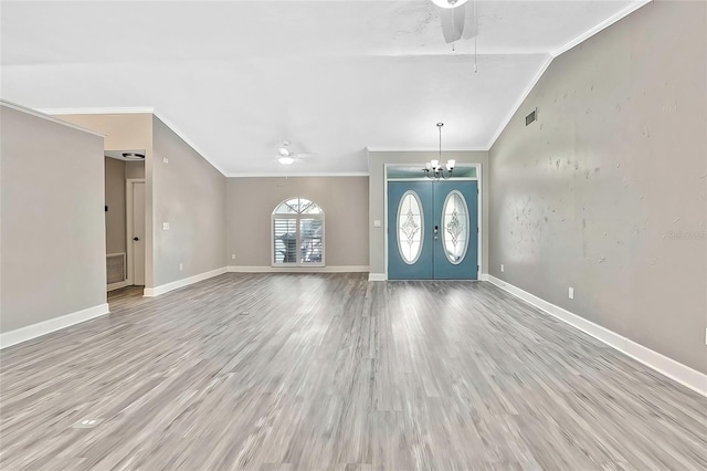 entryway featuring vaulted ceiling, ornamental molding, light hardwood / wood-style flooring, and french doors