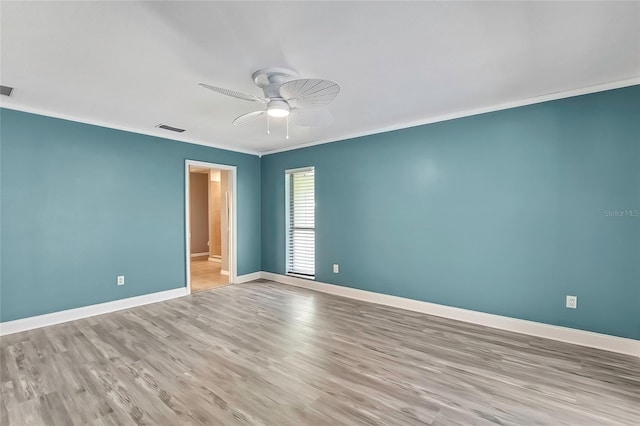 spare room featuring light wood-type flooring, ceiling fan, and ornamental molding