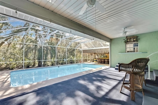 view of swimming pool with a lanai, ceiling fan, and a patio area