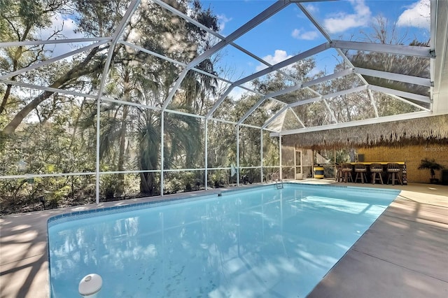 view of swimming pool with glass enclosure and a patio area