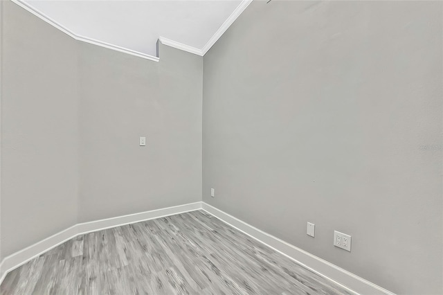 empty room with ornamental molding and light hardwood / wood-style flooring