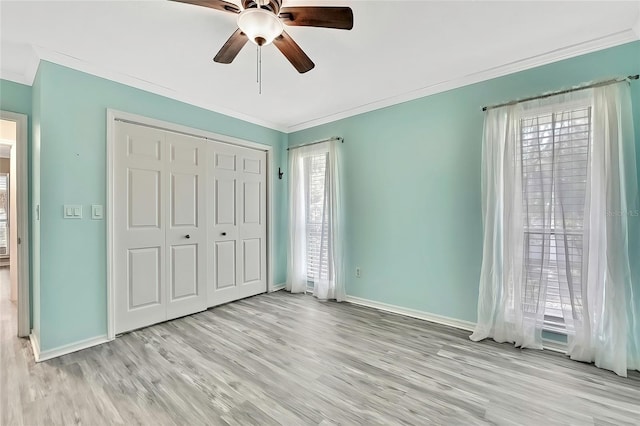 unfurnished bedroom with ceiling fan, a closet, crown molding, and light hardwood / wood-style flooring