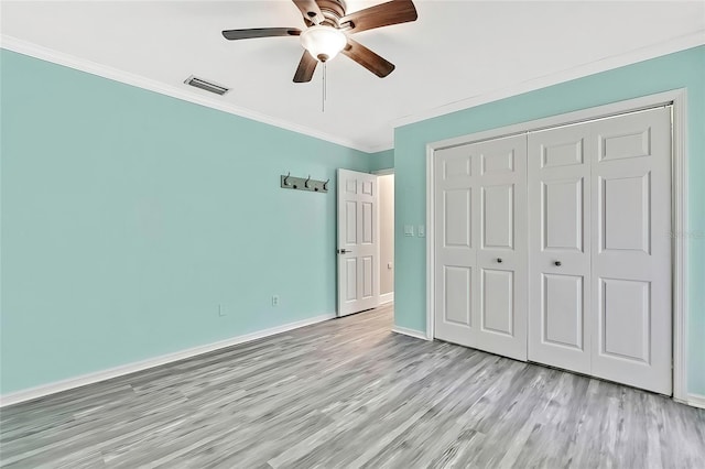 unfurnished bedroom featuring ceiling fan, ornamental molding, a closet, and light hardwood / wood-style floors