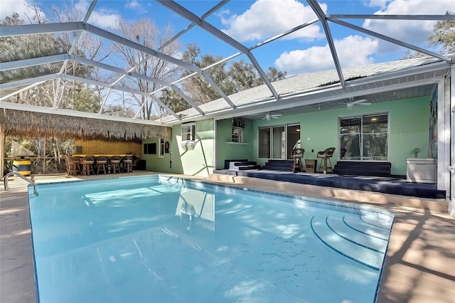 view of pool featuring ceiling fan, a lanai, and a patio area