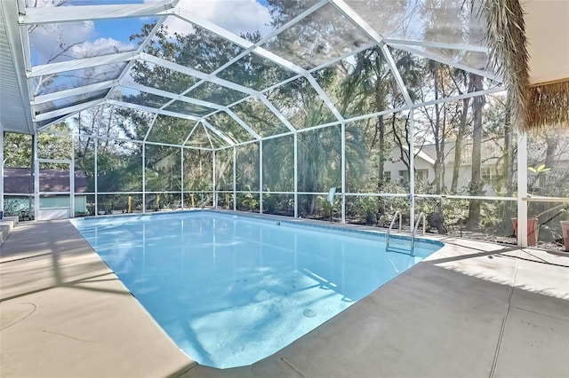 view of swimming pool featuring a patio area and glass enclosure