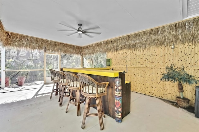 interior space with bar and ceiling fan