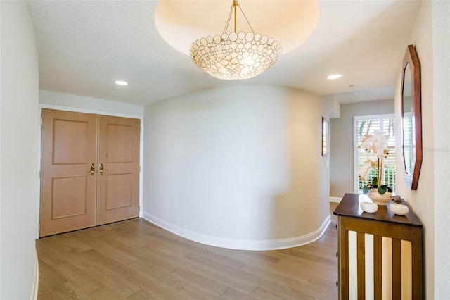 corridor with an inviting chandelier and hardwood / wood-style floors