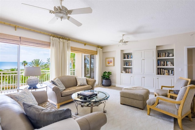 living room featuring a textured ceiling, ceiling fan, and built in shelves