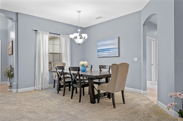 dining area featuring an inviting chandelier and light carpet