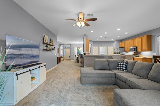 carpeted living room featuring ceiling fan