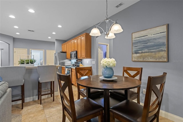 dining area featuring an inviting chandelier and light tile patterned floors