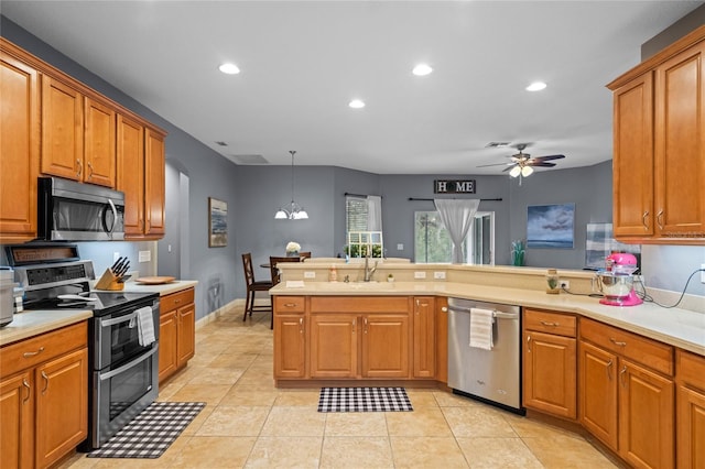 kitchen with pendant lighting, ceiling fan with notable chandelier, appliances with stainless steel finishes, light tile patterned flooring, and sink