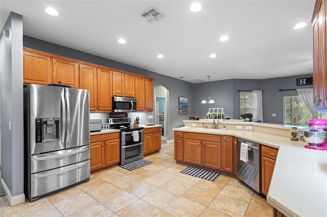 kitchen featuring sink, decorative light fixtures, light tile patterned floors, and appliances with stainless steel finishes