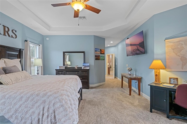 carpeted bedroom featuring a raised ceiling and ceiling fan